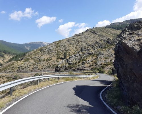 Carretera sinuosa en la montaña rodeada de un paisaje natural impresionante.