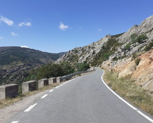 Carretera sinuosa en la montaña rodeada de un paisaje natural impresionante.