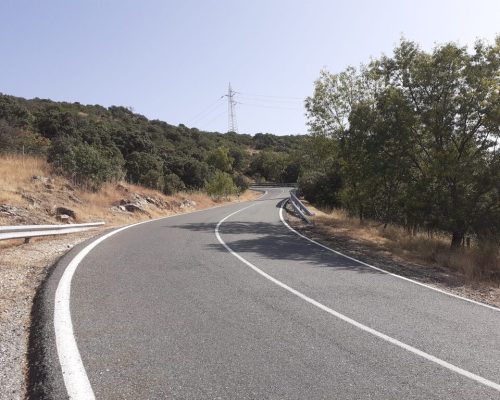 Vista de una carretera que gira a la derecha en un paisaje montañoso.