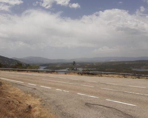 Vista de una carretera recta que serpentea a través de un paisaje montañoso.