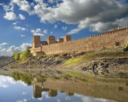 Vista de la oficina de turismo de Buitrago reflejada en el lago.
