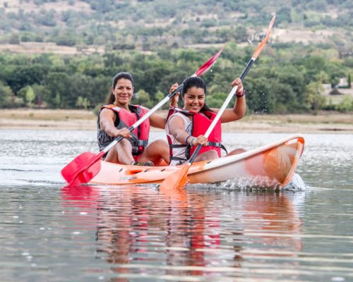 personas en piraguas en un embalse