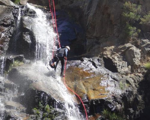 persona descendiendo una cascada en Somosierra