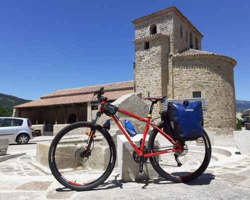 Vista de la iglesia de Prádena con una bicicleta
