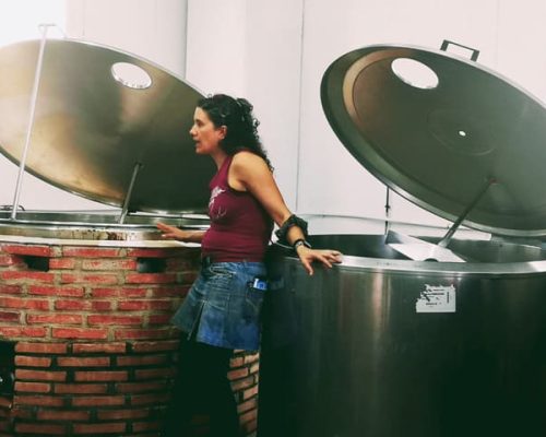 Mujer junto a tanques de fermentación en la fábrica de cerveza Bailandera.